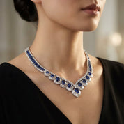 Close-up of a delicate Burma sapphire and diamond necklace on a black velvet cushion, featuring vivid blue sapphires and brilliant diamonds in a luxurious setting.