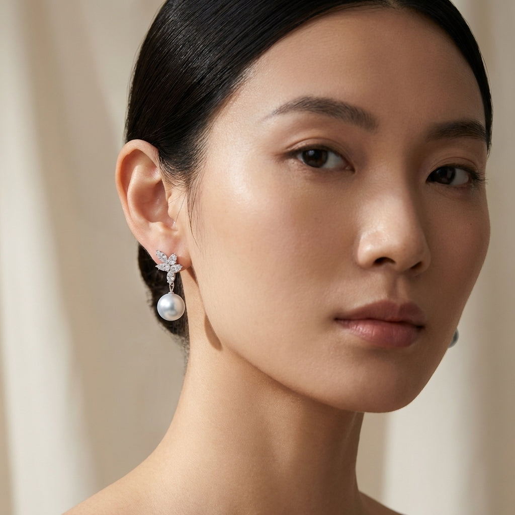 Close-up of celestial drop pearl and diamond earrings on an elegant East Asian female model with refined features, soft lighting highlighting intricate details.